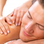 Female hands massaging young happy man